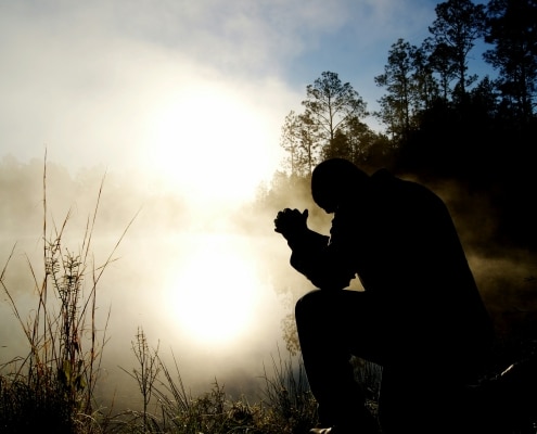 A Pentecostal Christian man praying, fostering a deeper relationship with God, representing Victory Chapel in New Hampshire.